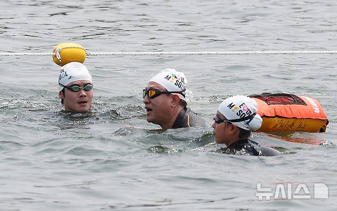 [서울=뉴시스] 조수정 기자 = 오세훈(가운데) 서울시장이 30일 서울 한강에서 제2회 쉬엄쉬엄 한강3종 축제 사전점검 및 깨끗한 한강 수질을 홍보하기 위해 잠실대교 남단 수중보에서 뚝섬수상안전교육장까지 1km 구간을 '수질 환상적'이라고 적은 부표를 몸에 매고 수영으로 도하하고 있다. 2025.05.30. chocrystal@newsis.com