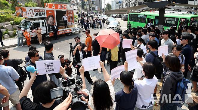 [서울=뉴시스] 추상철 기자 = 30일 오후 서울 동작구 중앙대학교 후문에서 대학생들이 유세를 펼치는 이준석 개혁신당 대선후보를 향해 혐오 발언 규탄 피켓을 들어 보이고 있다. 2025.05.30. scchoo@newsis.com