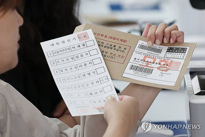 제21대 사전투표 D-1 (영종도=연합뉴스) 임화영 기자 = 28일 인천국제공항 1터미널에 설치된 제21대 대통령선거 사전투표소에서 관계자가 투표용지와 관외 사전투표자를 위한 회송용 봉투를 들어보이고 있다. 2025.5.28 hwayoung7@yna.co.kr