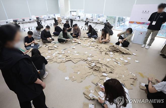 대선 사전투표 끝 (서울=연합뉴스) 김도훈 기자 = 제21대 대통령선거 사전투표 둘째 날인 30일 서울 중구 을지누리센터에 마련된 사전투표소에서 사전투표사무원들이 참관인 및 공정선거참관단이 지켜보는 가운데 관외투표함을 열어 투표용지 분류 작업을 하고 있다. 2025.5.30 superdoo82@yna.co.kr