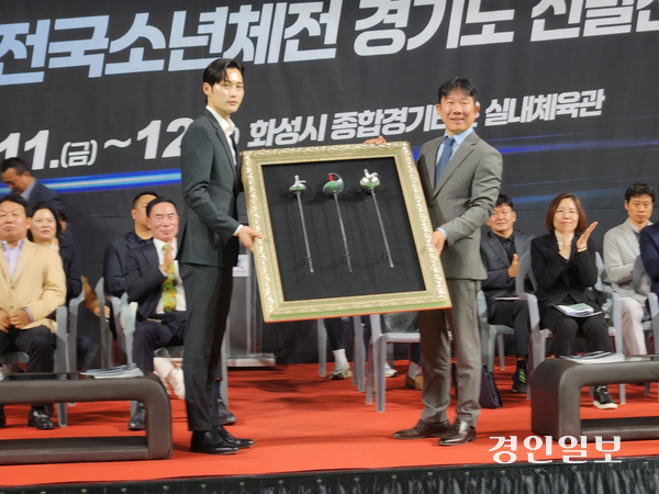 지난 12일 화성종합경기타운 실내체육관에서 열린 ‘제3회 경기도교육감배 초·중·고 펜싱선수권대회 겸 제54회 전국소년체전 경기도 선발전’ 개회식에서 김준호(왼쪽) 화성시청 펜싱팀 코치와 온현종 제4대 경기도펜싱협회장이 펜싱 칼 증정식을 한 가운데 행사 후 칼을 들고 기념촬영을 하고 있다. 2025.4.12 김형욱기자 /uk@kyeongin.com