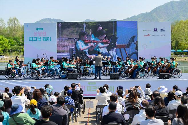 상상인그룹이 지난 26일 경기도 하남 미사경정공원에서 개최한 ‘2025 상상인 피크닉 데이’에서 ‘상상휠하모니 오케스트라’가 축하 공연을 하고 있다. (사진=상상인그룹)