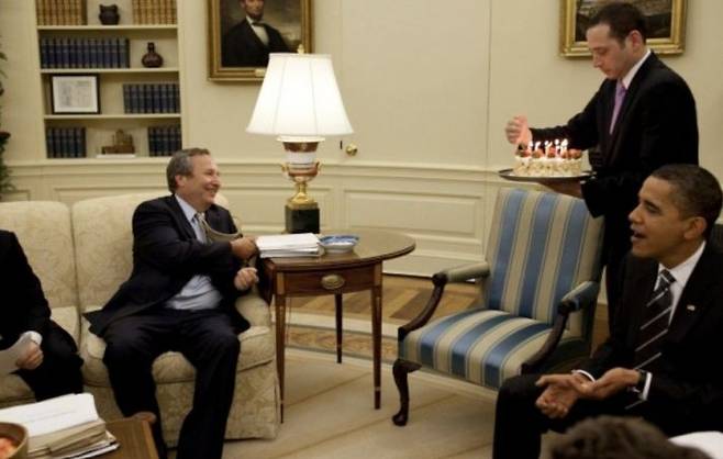 로런스 서머스(왼쪽) 전 국가경제위원장에 생일 케이크를 전달하는 버락 오바마(오른쪽) 전 대통령. 경제 위기 당시 서머스 위원장이 이끈 경제 고문들은 미국의 재정 승수를 1.4 이상으로 판단, 1000조원 이상에 달하는 천문학적인 재정 부양 패키지의 근거로 삼았다. 백악관 홈페이지