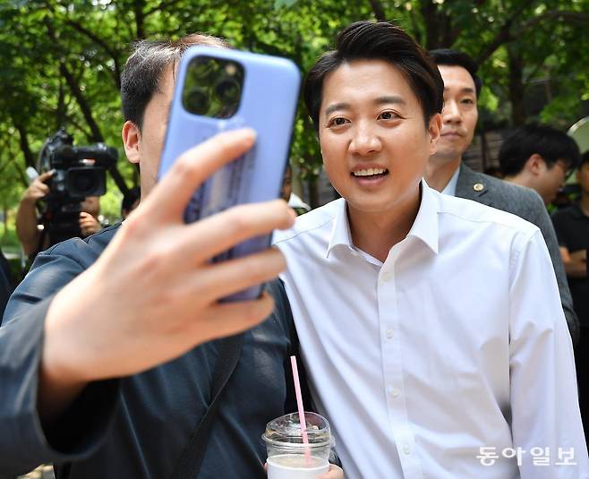 개혁신당 이준석 대선 후보가 30일 오후 서울 마포구 경의선숲길공원에서 지지자와 함께 휴대전화로 ‘셀카’를 찍고 있다. 신원건 기자 laputa@donga.com