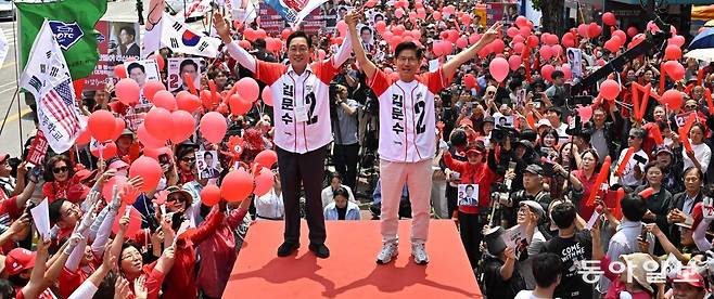 국민의힘 김문수 대선 후보(오른쪽)가 30일 경기 여주시 여주시청 앞에서 열린 유세에서 두 손을 들고 지지를 호소하고 있다. 김 후보 지지자 수백 명이 모여 태극기와 성조기, 빨간 풍선 등을 들고 있다. 여주=장승윤 기자 tomato99@donga.com