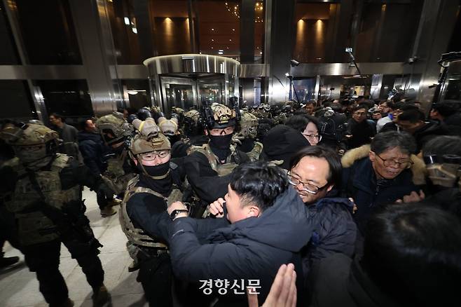 윤석열 전 대통령이 비상계엄을 선포한 후 자정을 넘긴 지난해 12월4일 새벽 서울 여의도 국회본청 앞에서 무장군인들이 진입을 시도하다 국회 직원 등 시민들에게 제지당하고 있다. 성동훈 기자