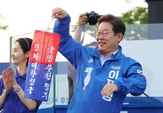 더불어민주당 이재명 대선 후보가 30일 충북 충주시 충주체육관 시계탑광장에서 열린 유세에서 ‘진짜 대한민국’이라고 쓰인 청사초롱을 들어보이고 있다. 연합뉴스
