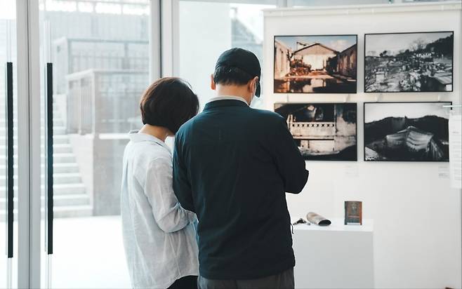 관람객들이 지난 19일 대전시 유성구 함께하는교회(김요한 목사) 지하 2층 갤러리에서 진행되는 ‘재(災), 건(建)’ 사진전을 감상하는 모습. 함께하는교회 제공