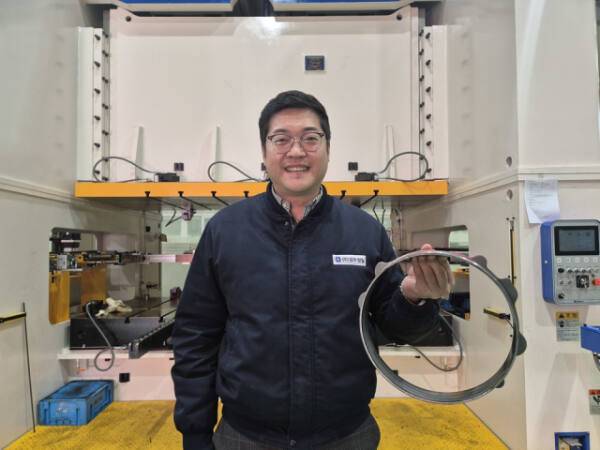 박진수 대표가 경우정밀에서 제조하는 자동차 서포트링 제품을 들고 있다. 김샛별 기자