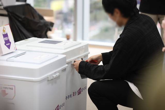 제21대 대통령선거 사전투표 둘째 날인 30일 서울 중구 을지누리센터에 마련된 사전투표소에서 선거관리관이 투표함 특수봉인지를 제거하고 있다. 연합뉴스