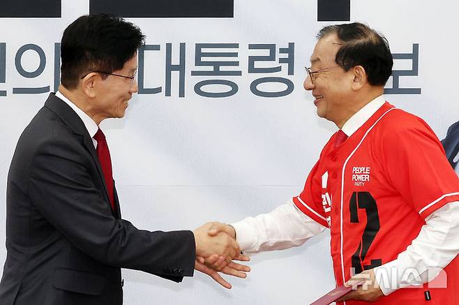 [서울=뉴시스] 조성우 기자 = 김문수(왼쪽) 국민의힘 대선후보가 15일 오전 서울 여의도 국회에서 열린 중앙선대위 회의 및 중앙선대위 임명장 수여식에서 이정현 전 새누리당 대표에게 공동선대위원장 임명장을 수여하고 있다. 2025.05.15. xconfind@newsis.com