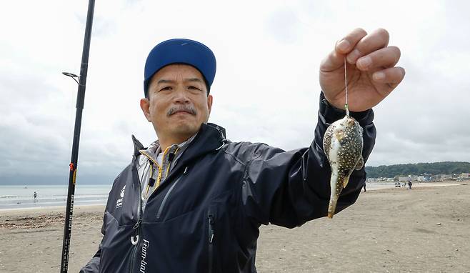 31일 일본 카나가와현 가마쿠라시 에노시마섬 일원 자이모쿠자 해변에서 열린 '2025 세계드론낚시대회 in Japan'에서 3등을 한 일본 아라키 팀이 잡은 복어를 들고 기념촬영을 하고 있다.