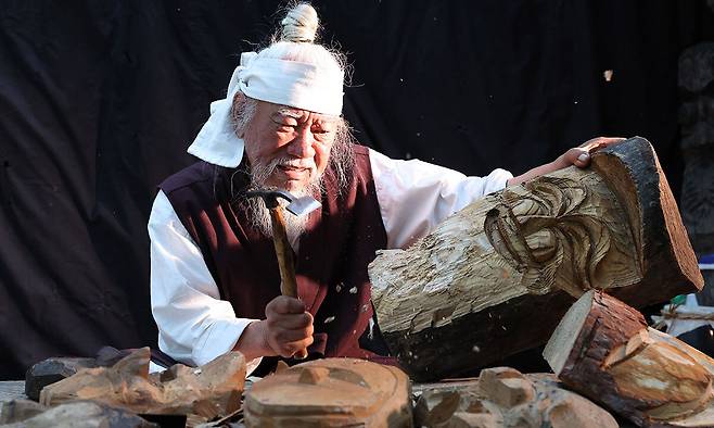 김종흥(70) 장승 명인이 그의 작업장인 ‘목석원’에서 장승을 깎고 있다. 그가 조각한 장승은 모두 다른 표정과 형체를 가지고 있다. 장승은 깎는 작업을 끝났다고 마무리되는 것이 아니라 특별한 의식을 치르고 지정한 장소에 세워야 비로소 완성된다. 2002년 국가무형문화재 제108호 목조각 이수자로 인정받았고, 2013년에는 한국예술문화재단총연합회로부터 장승 명인으로 지정받았다.