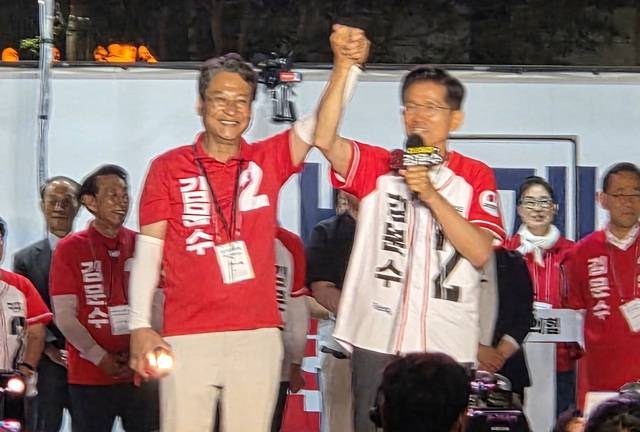 경기도지사 당시 보좌관으로 일했던 배진석 후보의 손을 치켜들며 지원을 당부하고 있다.