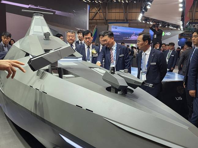 신익현 LIG넥스원 대표이사(사진 오른쪽)와 석종건 방위사업청장, 신용화 LIG넥스원 미래전장사업본부장이 해검-X에 관해 대화를 나누고 있다./사진=LIG넥스원 제공