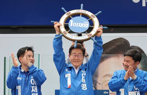 이재명 더불어민주당 대선 후보가 31일 경기도 평택시 배다리 생태공원 앞에서 열린 유세에서 선물 받은 조타기를 들어보이고 있다. 김성룡 기자