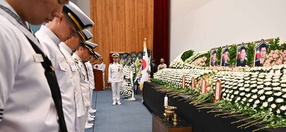 1일 경북 포항 해군항공사령부 내 강당에서 엄수된 해군 해상초계기 917호기 추락 사고 순직자들에 대한 합동 영결식에서 해군 장병들이 헌화 후 묵념을 하고 있다. 해군