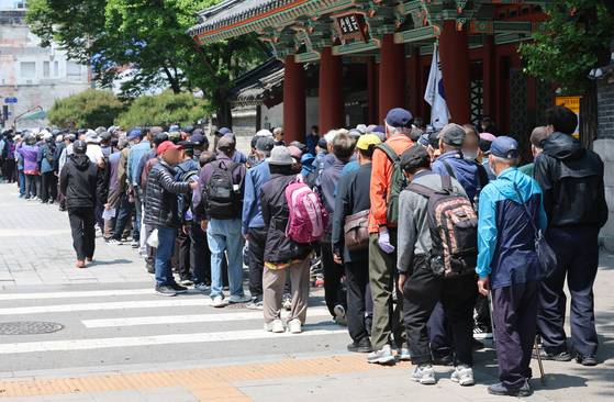 Senior citizens wait in line for free meals at Tapgol Park in Jongno District, central Seoul, on May 12. [NEWS1]