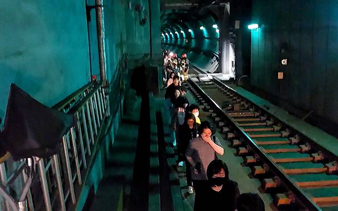 31일 오전 서울 지하철 5호선 마포역~여의나루역 구간을 지나는 열차에서 방화로 인한 화재가 발생, 승객들이 선로를 통해 대피하고 있다.&nbsp; &nbsp;&nbsp;영등포소방서 제공.