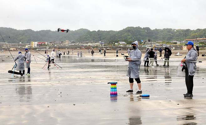 월척을 향해 지난달 31일 일본 가나가와현 가마쿠라시 에노시마 자이모쿠자 해변에서 열린 ‘2025 세계드론낚시대회 in Japan’에서 참가자들이 드론 낚시를 하고 있다. 드론 낚시는 낚싯줄과 미끼를 드론이 운반해 참가자가 원하는 지점에 투하한다.가마쿠라=이재문 기자