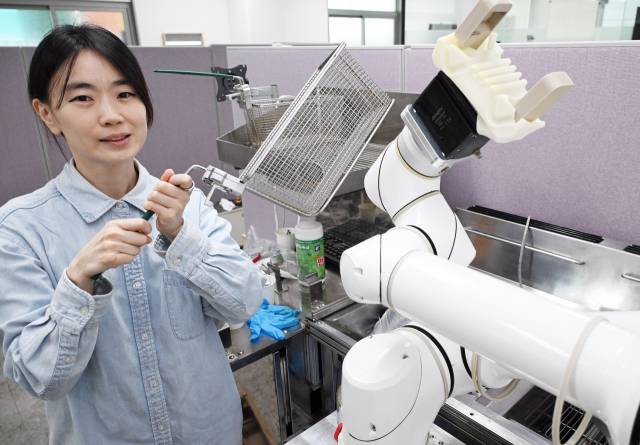 강지영 로보아르테 대표가 인터뷰를 마친 후 조리로봇 옆에서 포즈를 취하고 있다. 오승현 기자