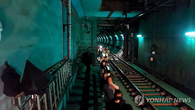 5호선 지하철 방화 화재, 대피한 승객들 (서울=연합뉴스) 지난달 31일 서울지하철 5호선 열차 안에서 방화로 인해 승객들이 지하 터널을 통해 대피하는 사건이 발생했다. 사진은 화재로 인해 대피하는 승객들의 모습. 2025.6.1 [영등포소방서 제공. 재판매 및 DB 금지] photo@yna.co.kr