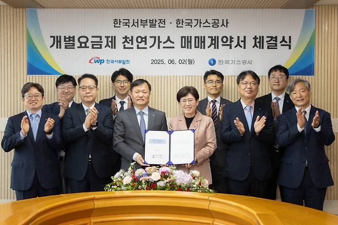 최연혜(오른쪽 다섯째 )한국가스공사 사장과 이정복(왼쪽 다섯째) 한국서부발전 사장이 2일 서울 LNG비지니스허브에서 800만t 규모 천연가스 매매계약을 체결한 뒤 직원들과 기념촬영을 하고 있다. <한국가스공사 제공>