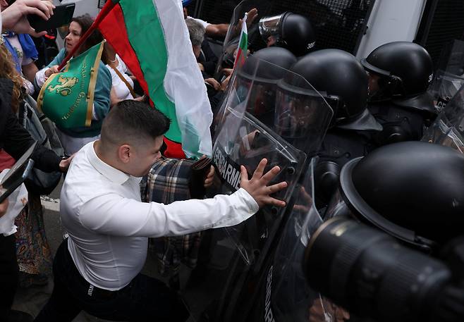 지난달 31일 불가리아 수도 소피아에서 벌어진 유로존 가입 반대 시위에서 참가자가 유럽연합 집행위원회 사무소에 접근하려다 경찰과 대립하고 있다. /연합뉴스