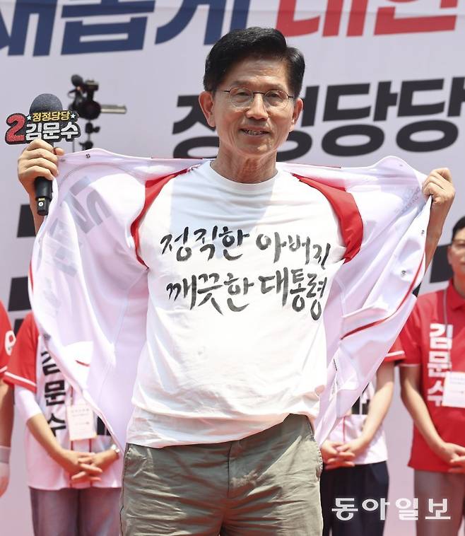 국민의힘 김문수 대선 후보가 1일 서울 강남구 수도권 광역급행철도(GTX) 삼성역 공사장 앞에서 열린 유세에서 더불어민주당 이재명 후보의 방탄조끼를 비판하며 웃옷을 벗고 있다. 김 후보는 ‘정직한 아버지 깨끗한 대통령’ 문구가 적힌 티셔츠를 내보였다. 장승윤 기자 tomato99@donga.com