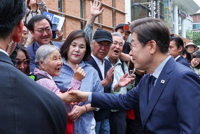 이재명 더불어민주당 대통령 후보가 제21대 대통령선거를 하루 앞둔 2일 오후 경기 성남시 주민교회에서 기자회견을 마친 뒤 성남시의료원 앞에 대기하고 있던 시민들과 인사를 나누고 있다. 뉴스1