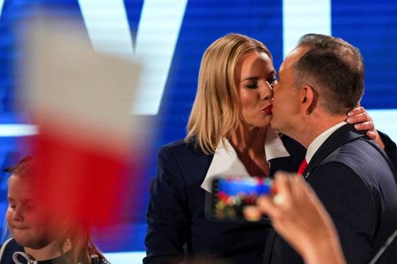 폴란드 대선 민족주의 우파 야권 후보인 무소속 카롤 나브로츠키가 1일(현지시간) 바르샤바에서 대선 2차 투표 출구조사 결과를 확인한 뒤 아내 마르타 나브로츠카와 키스하고 있다. 로이터=연합뉴스