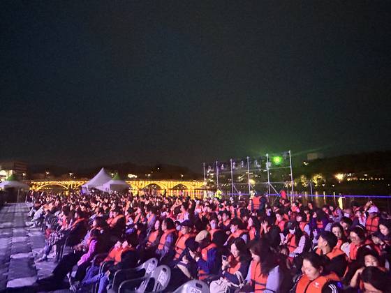 경남 진주성 외곽 야외무대에서 펼쳐지는 실경역사뮤지컬 ‘의기 논개’(연출 고능석)를 수상특설객석에서 관람하는 관객들. 만약을 대비해 입장 때 구명조끼를 지급받고 관람 내내 착용해야 한다. '의기 논개'는 (사)극단현장이 주최·주관하고 문화체육관광부·진주시 후원하는 작품으로 올해 5월 한달간 총 10회 공연이 거의 매회차 매진됐다. 강혜란 기자