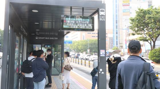 경남 창원시 시내버스 노조가 지난달 28일 첫차부터 파업에 돌입한 가운데 이날 오전 성산구 용호동 한 버스정류장에서 시민들이 시가 비상수송대책으로 마련한 임시 버스를 기다리고 있다. 정류장에 설치된 창원시버스정보시스템 전광판에 '시내버스 파업'이라는 알림 문구가 지나가고 있다. 연합뉴스