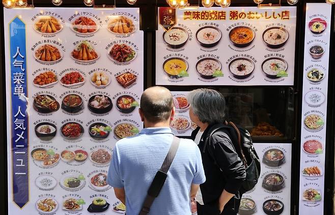 서울 명동에서 외국인 관광객들이 외국어로 된 메뉴를 살펴보는 모습. 사진=연합뉴스