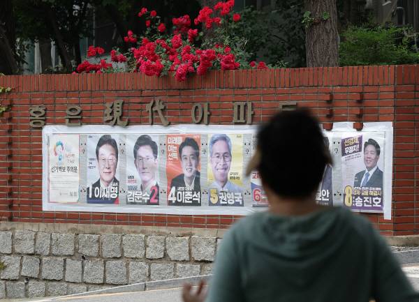 제21대 대통령선거를 하루 앞둔 2일 서울 한 아파트 장미 화단 아래에 대선후보 벽보가 붙어 있다. 연합뉴스