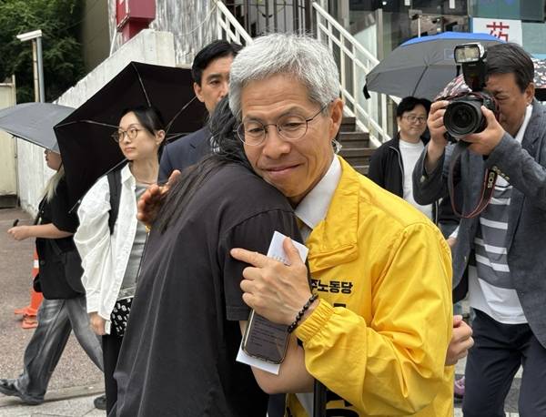 ▲대선을 하루 앞둔 2일 오전 서울지하철 2호선 강남역 앞,'비동의 강간죄'라고 쓴 손팻말을 든 시민이 반가움과 울먹임이 뒤섞인 표정으로 유세 중인 권영국 민주노동당 후보에게 다가가 악수를 청했다. 사진=윤유경 기자.