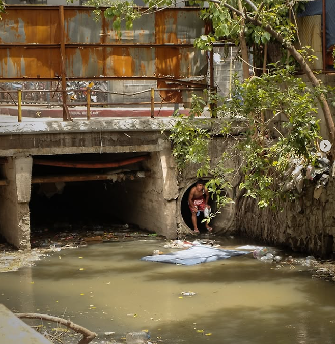 하수구에서 나온 여성을 촬영한 사진작가가 SNS에 공유한 또다른 사진. 한 남성이 배수구에서 나오고 있다. [사진 = 인스타그램 iammrthirty]