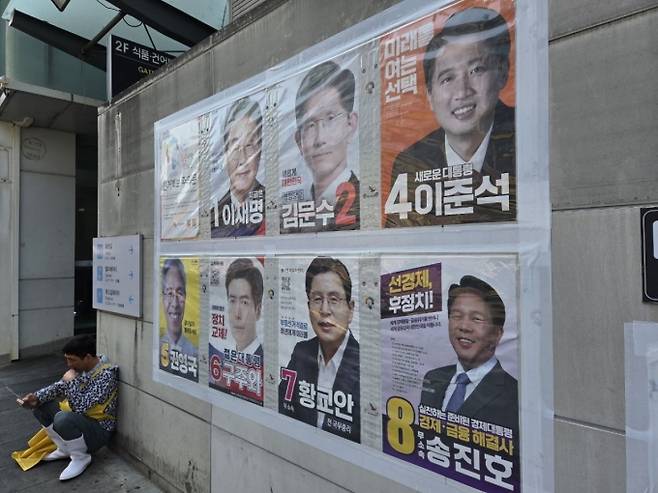 부산 자갈치시장 건물 앞에서 한 상인이 휴대전화를 보고 있다./ 사진=유재희 기자.