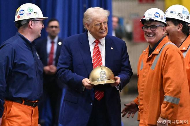 (펜실베이니아 AFP=뉴스1) 류정민 특파원 = 도널드 트럼프 미국 대통령이 30일(현지시간) 일본제철과 US스틸의 '파트너십'을 기념하기 위해 찾은 펜실베이니아주 웨스트미플린 소재 US스틸-어빈제철소에서 선물 받은 황금 헬맷을 들고 있다. 2025.05.30   ⓒ AFP=뉴스1  Copyright (C) 뉴스1. All rights reserved. 무단 전재 및 재배포,  AI학습 이용 금지. /사진=(펜실베이니아 AFP=뉴스1) 류정민 특파원