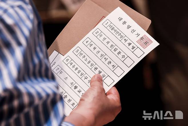 [서울=뉴시스] 정병혁 기자 = 제21대 대통령선거 사전투표 첫 날인 29일 서울 구로구 구로구민회관 대강당에 설치된 사전투표소를 찾은 유권자가 투표용지를 들고 있다. 2025.05.29. jhope@newsis.com