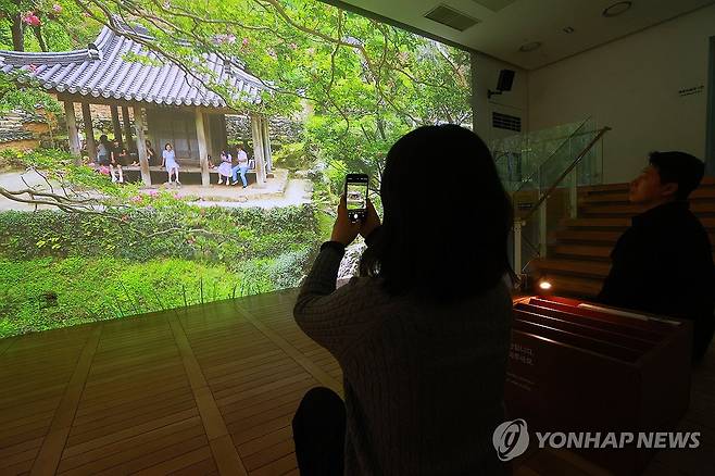차경으로 즐기는 찰나 (서울=연합뉴스) 진연수 기자 = 24일 오전 서울 종로구 세종문화회관 미술관에서 열린 '미음완보(微吟緩步), 전통 정원을 거닐다' 전시 언론공개회에서 참석자들이 미디어 아트 영상을 관람하고 있다. 
    이번 전시는 국가유산청이 2021년부터 전통 조경을 정밀 실측·조사하며 축적해 온 데이터를 활용해 옛사람들이 꾸민 정원과 자연경관을 디지털 기술로 생생하게 구현했다. 2025.2.24 jin90@yna.co.kr