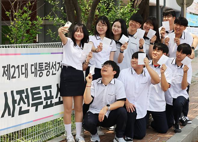 제21대 대통령선거 사전투표 첫날인 지난달 29일 경기도 수원시 장안구 연무동행정복지센터에 마련된 투표소에서 투표를 마친 삼일공업고등학교 3학년 학생들이 투표확인증들 들고 인증사진을 찍고 있다. /연합뉴스