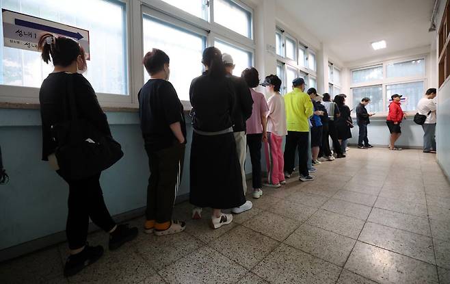 제21대 대통령 선거일인 3일 서울 강동구 성내중학교 과학실험실에 마련된 성내1동 제2투표소에서 유권자들이 줄서서 투표 시작을 기다리고 있다. 2025.6.3/뉴스1