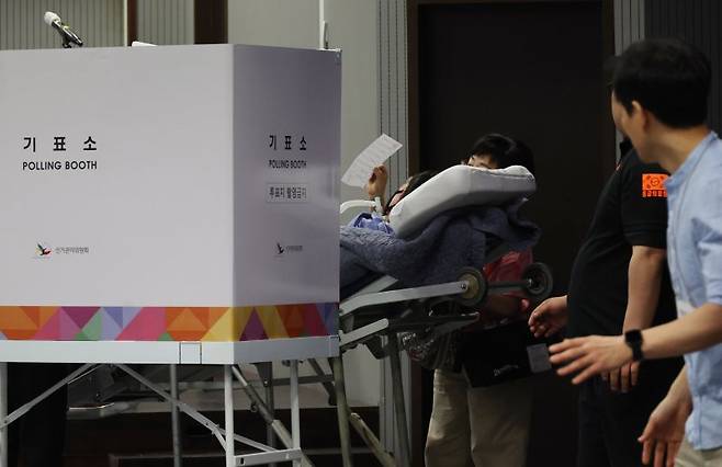 제21대 대통령 선거일인 3일 서울 용산구 중부기술교육원에 마련된 한남동 제3투표소에서 한 환자가 보호자와 구급대원의 도움을 받아 투표에 참여하고 있다. 연합뉴스