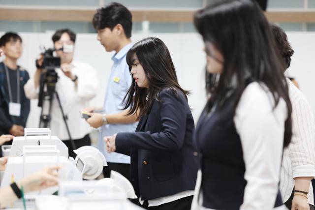 제21대 대통령 선거 사전투표 첫날인 지난달 29일 광주 서구 화정2동 사전투표소에서 고교 3학년 학생들이 생애 첫 투표를 위해 투표용지를 건네받고 있다. 연합뉴스