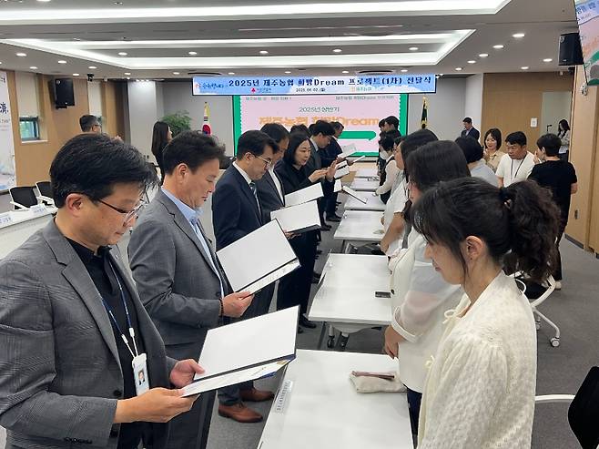 제주농협 등 관계자들이 수혜 대상자들에게 ‘희망Dream 프로젝트’ 맞춤형 지원서를 전달하고 있다. (제주농협 제공)