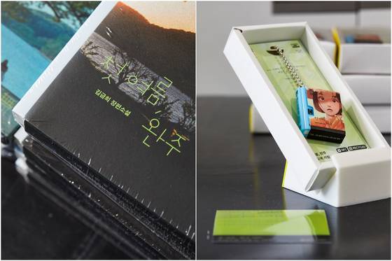The audiobook for ″My First Summer, Wanju,″ left, and a keyring for the novel. The audiobook is available on the Welaaa app. [LCDC SEOUL]