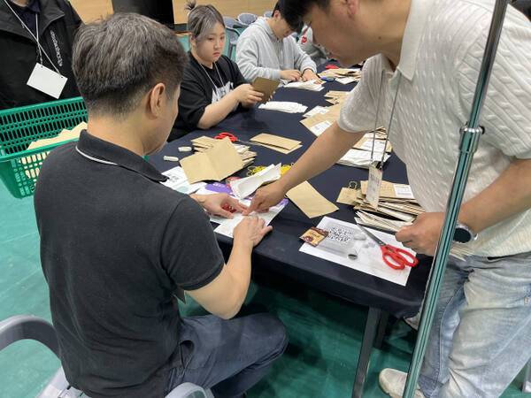 3일 제21대 대통령 선거 개표가 진행 중인 수원종합운동장 실내체육관에서 선관위 직원이 잘린 투표 용지를 테이프로 붙이고 있다. 박소민기자