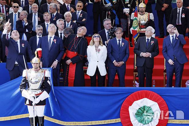 [로마= AP/뉴시스] 6월 2일 이탈리아의 국경일인 '공화국의 날' 79주년 축제 행사가 열린 로마에서 공중 에어쇼를 참관하는 조르자 멜로니 총리(가운데)와 세르지오 마타렐라 대통령을 비롯한 정부 장관들과 상하원 의원들.  2025. 06. 03.