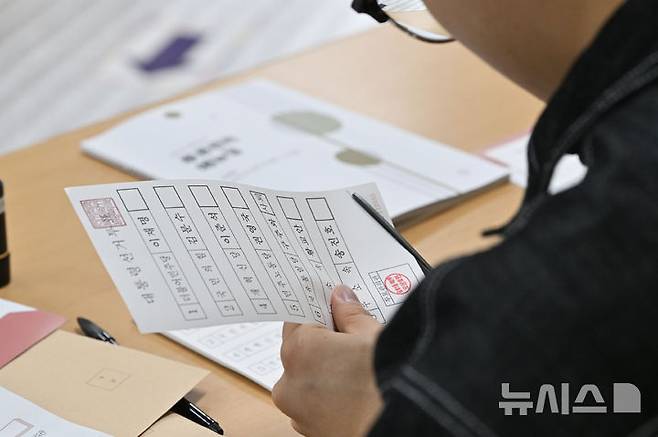 [광주=뉴시스] 이영주 기자 = 제21대 대통령 선거 본투표가 열리는 3일 오전 광주 서구 금호중학교에 마련된 금호1동 제2투표소에서 선거사무원이 유효한 투표용지를 준비하고 있다. 2025.06.03. leeyj2578@newsis.com